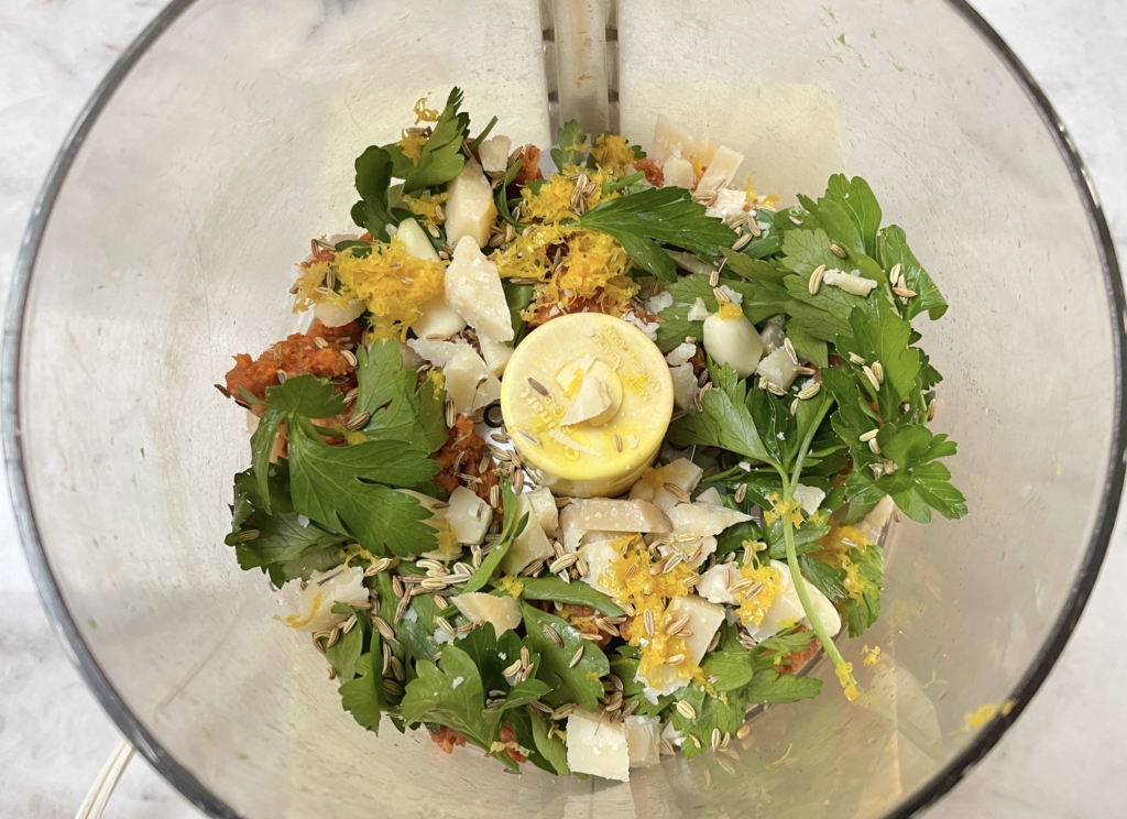 Place lemon zest,  chorizo, Parmesan, fennel seeds, parsley, and garlic cloves in the food processor. 