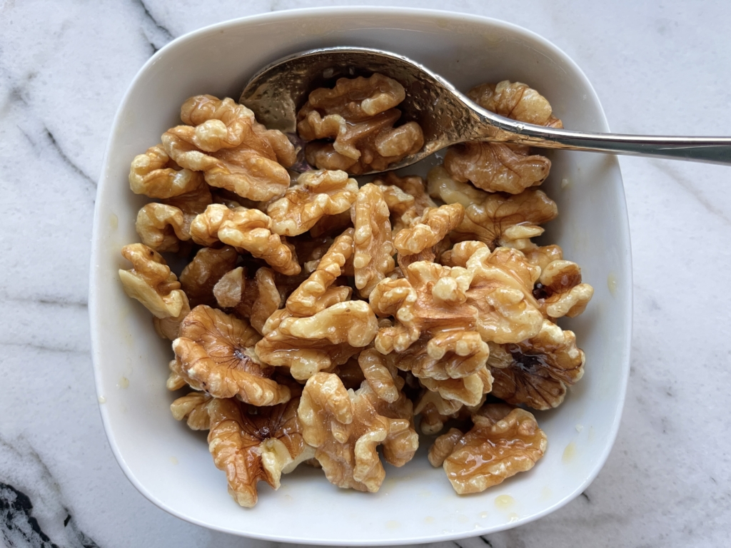 Combine walnuts with maple syrup, olive oil, and fresh herbs (if using).