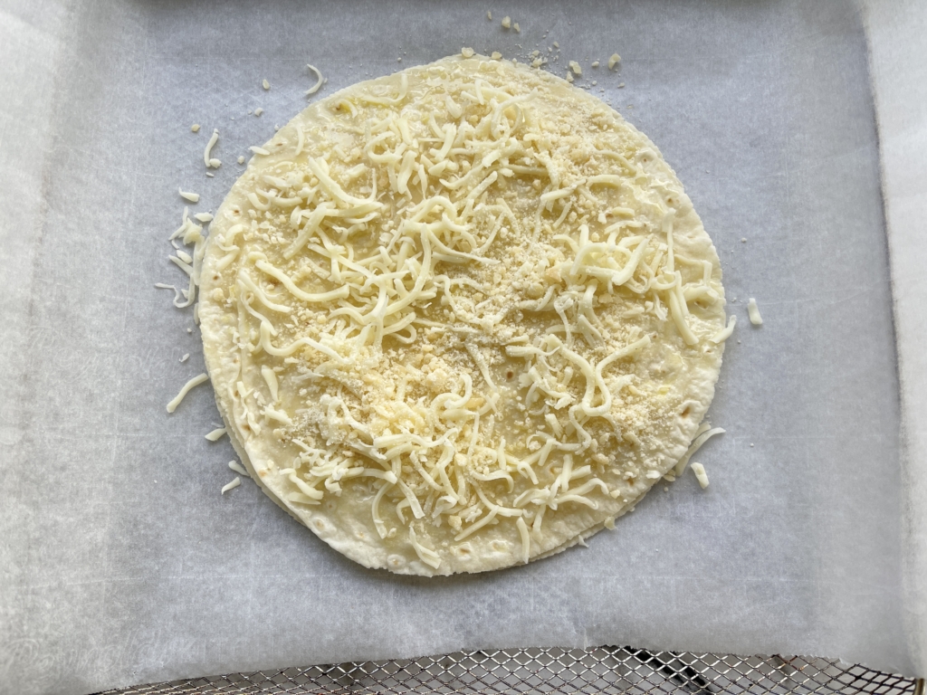 Next step is to scatter the remaining 2 heaping tablespoons of shredded mozzarella cheese and 2 teaspoons grated parmesan cheese on top of the oil.