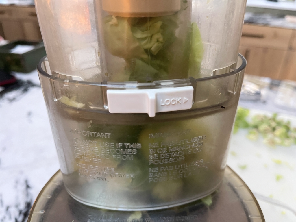 Insert the slicing blade with its attachment into the food processor. Then place as many Brussels sprouts as will fit into the feed tube. Turn on the food processor and use the food pusher to press the Brussels sprouts through the blade. Repeat until all Brussels sprouts are sliced. 