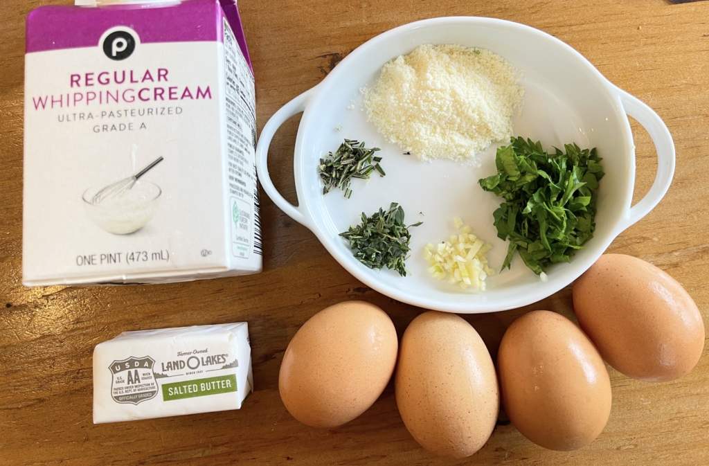 ingredients - eggs, heavy cream, butter, rosemary, thyme, parsley, garlic and parmesan