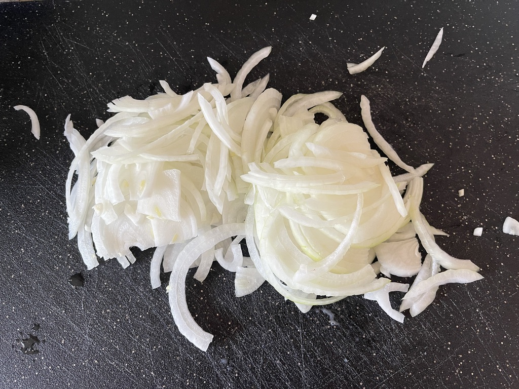 Cut the onions in half vertically through the root and then use a mandolin to thinly slice the onions into half moons.