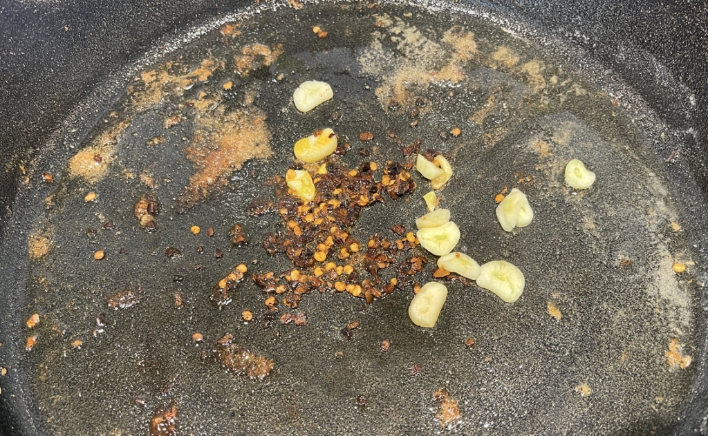Keep heat on medium and add another tablespoon of oil to the same pan. Then add the garlic and red pepper flakes. Cook for 30 seconds, until fragrant.