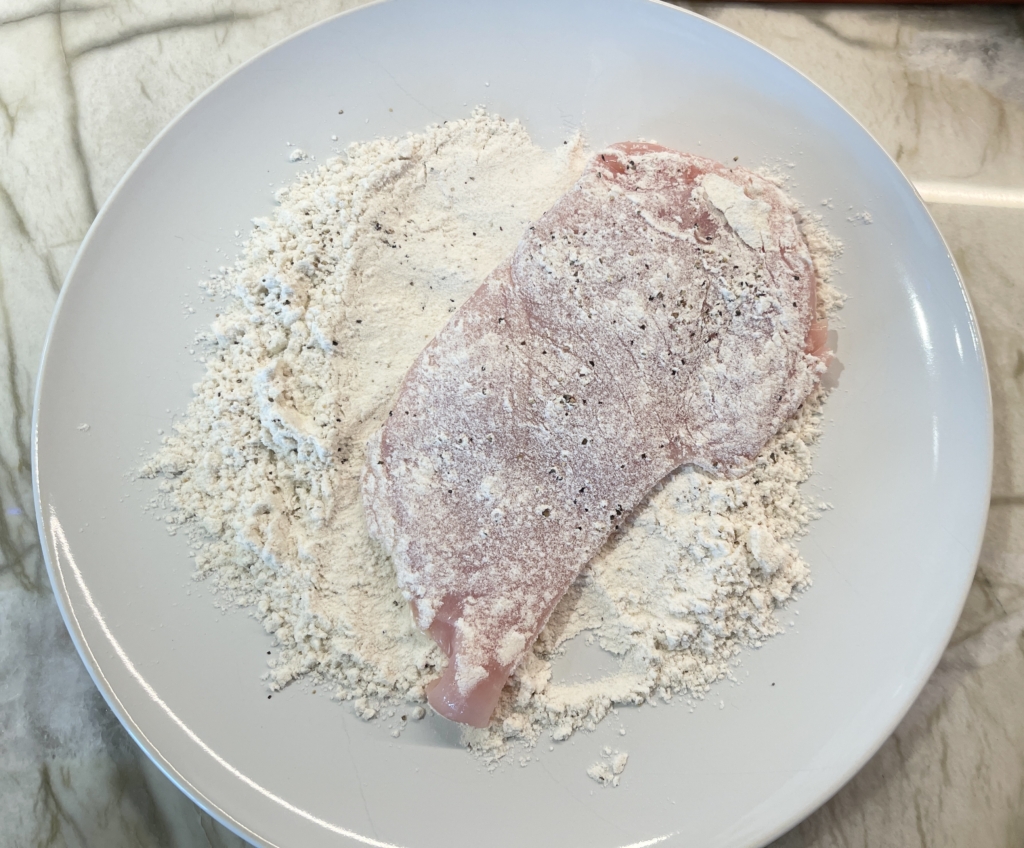 Season gluten free flour with one teaspoon kosher salt and 1/2 teaspoon black pepper. Mix until combined. Set aside. Dredge each breast in the flour and shake off any excess flour.