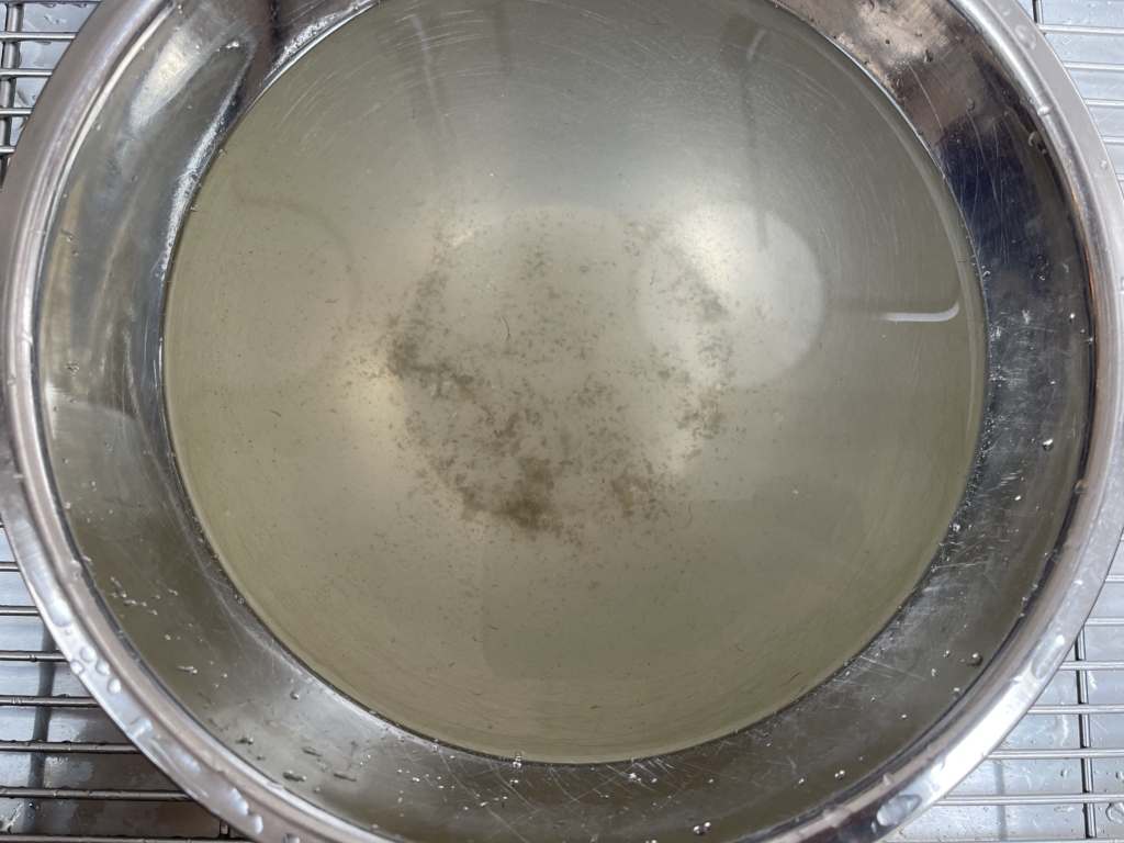 After a 1/2 hour, remove the oysters from the water and place on a plate or cutting board. Dirt and sand will have gathered at the bottom of the bowl. Discard the water. If you have particularly dirty oysters, you may want to repeat this step! Lastly, take a paper towel and wipe each oyster to remove any excess dirt or sand on the outside shell of the oyster.