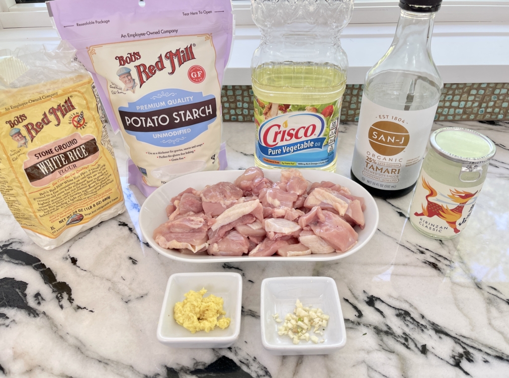 ingredients - chicken thighs with skin, potato starch, white rice flour, gluten free soy sauce, fresh ginger, garlic, sake, kosher salt and freshly ground pepper.