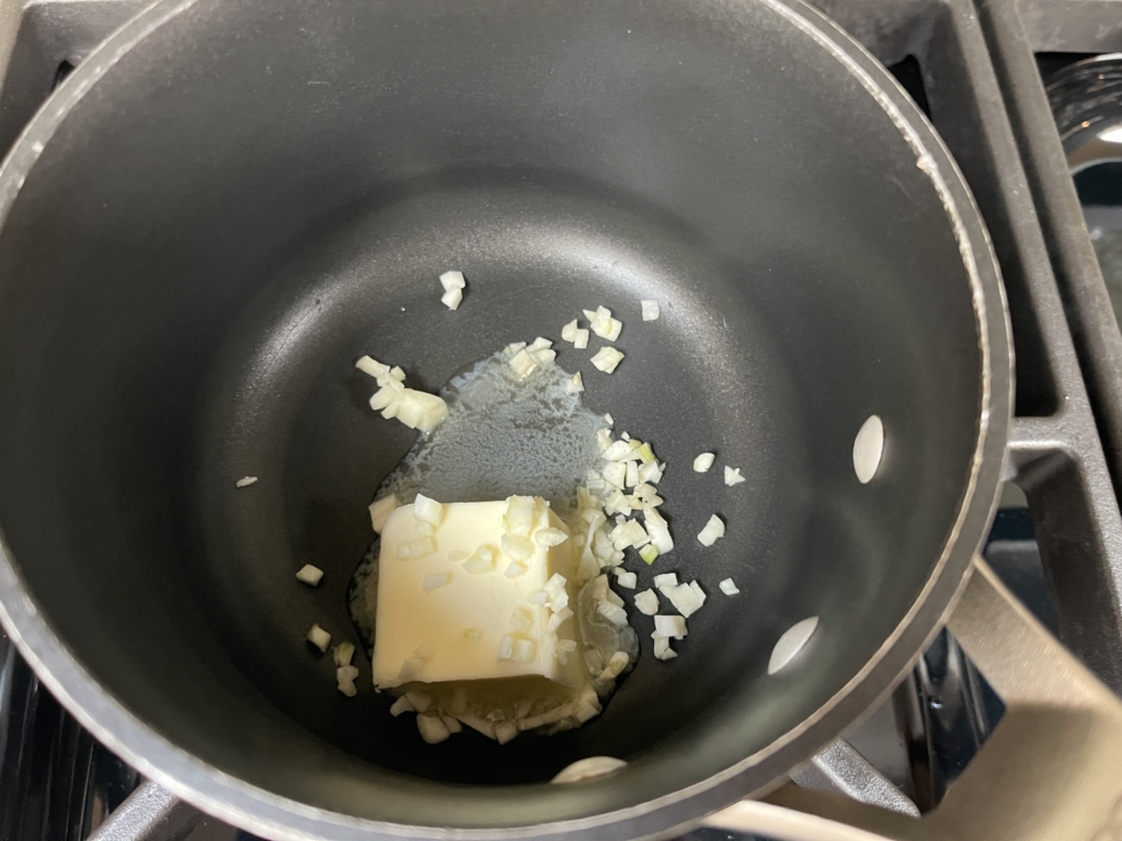 While oysters are in the water, prepare the Herb Butter Sauce. Place the garlic and butter in a small saucepan on medium heat.